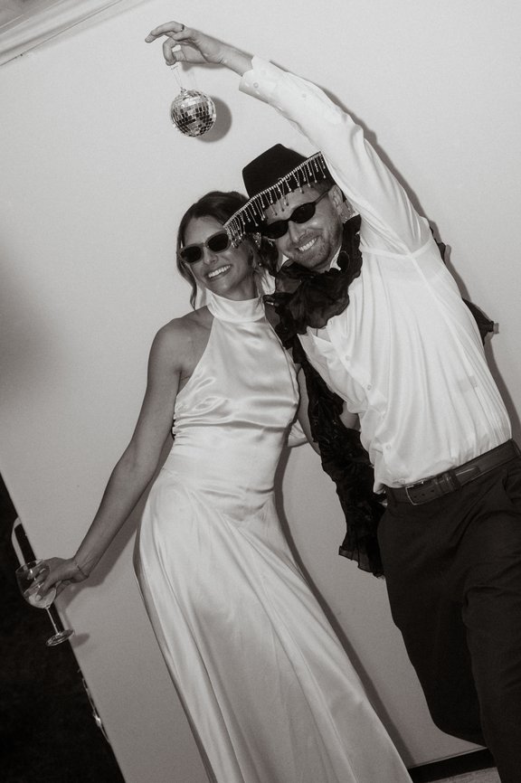 A couple dancing under a disco ball in the booth