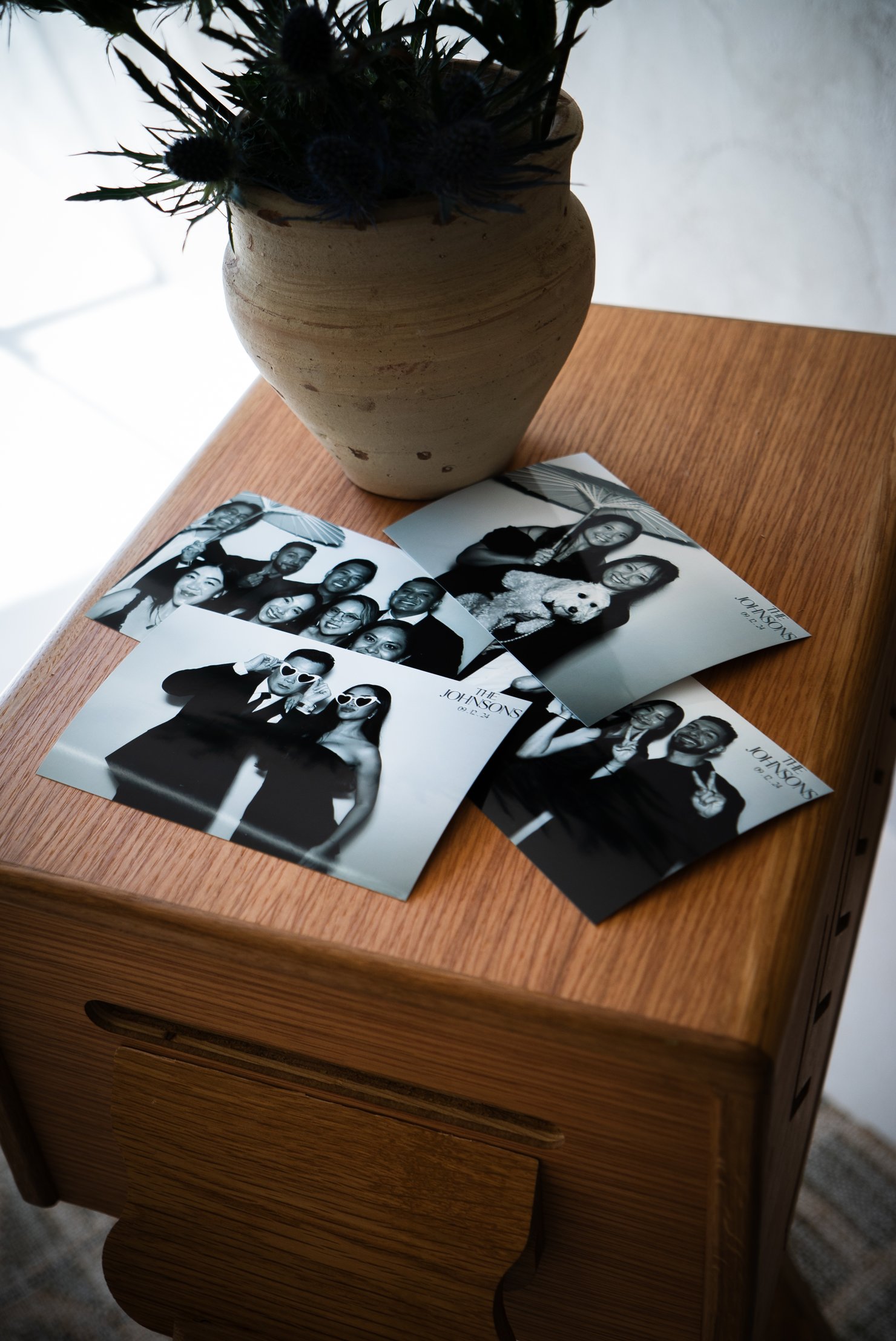 Printed photo strips laid out on top of the booth beside a vase